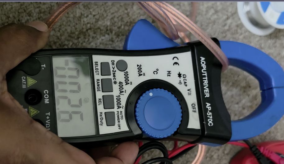 Clamp ammeter zeroed out, showing a −2.6 A offset before any load is applied.