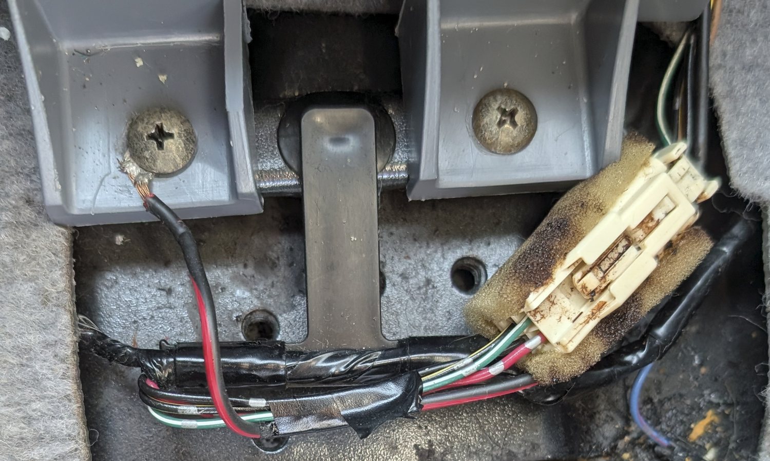 Diagram showing the ground connection point under the car's arm rest.