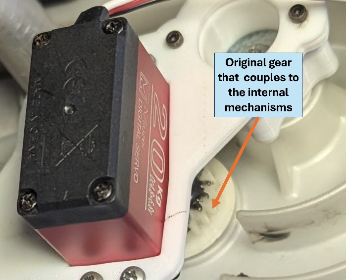The servo mounted in place, with the original gear that couples into the car's internal temperature control mechanism highlighted behind it.