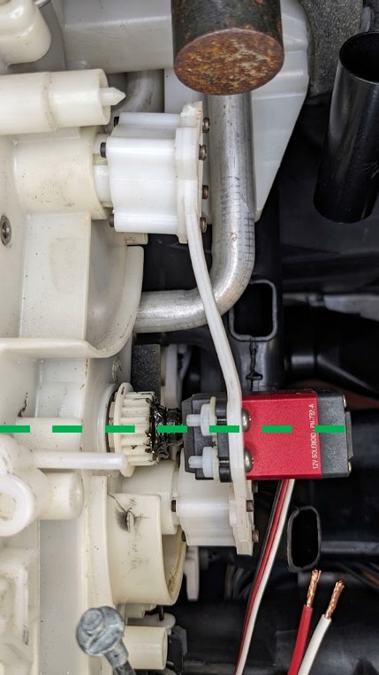 The assembled gear-and-servo coupling installed in the car, with a dashed line marking the alignment between the servo's output shaft and the gear's axis.