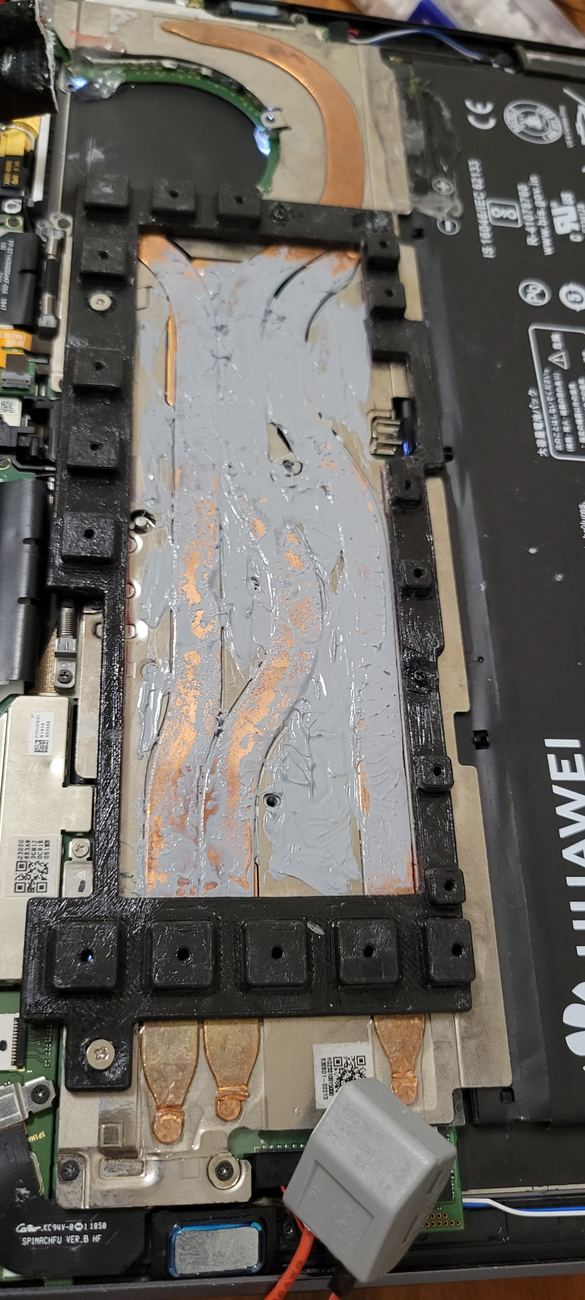 3D-printed frame mounted on the existing screw holes, holding the heatsink over the stock heat pipes, with thermal paste applied for contact.