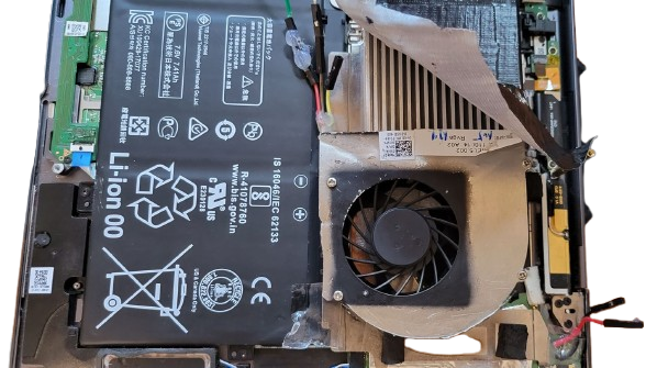 Bottom-up view of the fan mounted beside the battery, pulling air from above and blasting it sideways across the heatsink fins.
